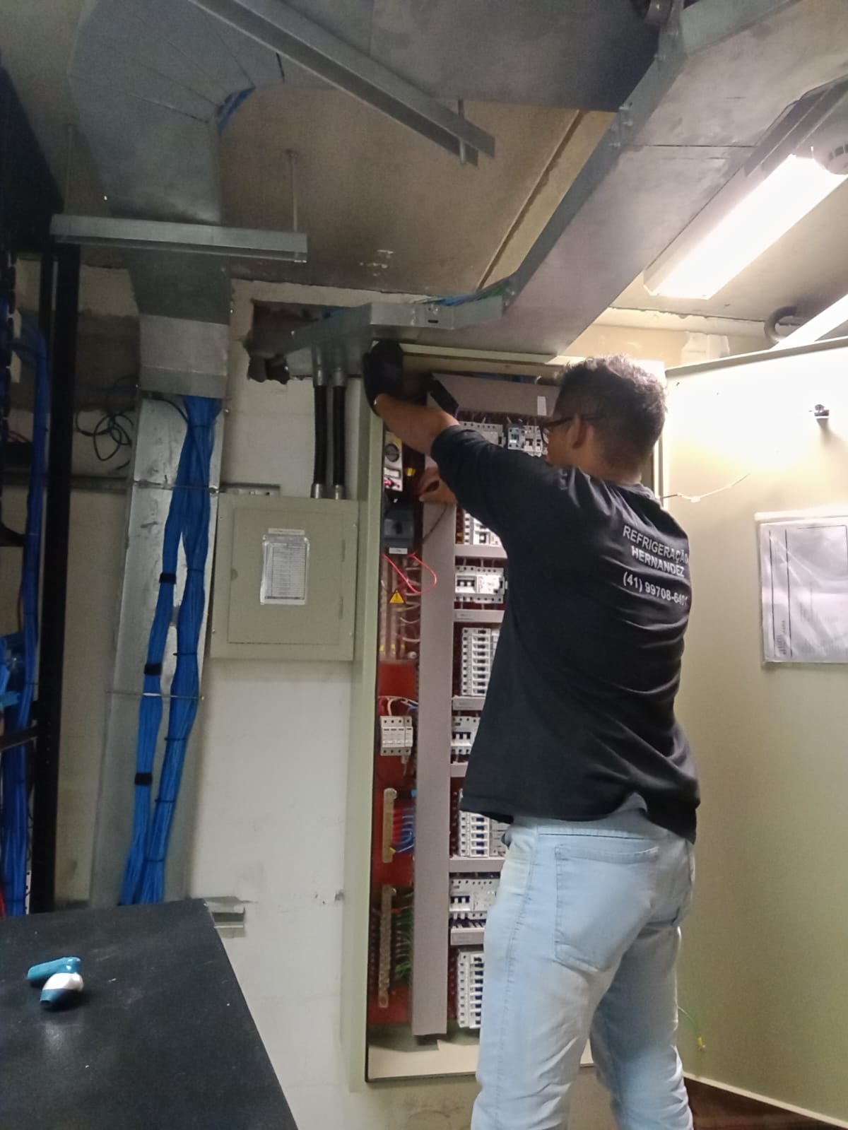 Técnico verificando painel e componentes de refrigeração